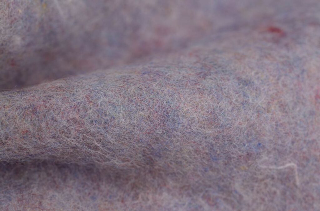 Close-up of natural lavalan recycled wool fibers used in sustainable insulation.