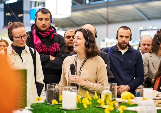 Speaker addressing visitors at a trade fair stand